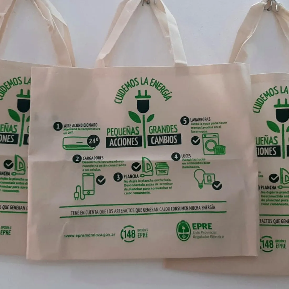 Bolsa de friselina rosa con asas de cinta gris y diseño floral impreso