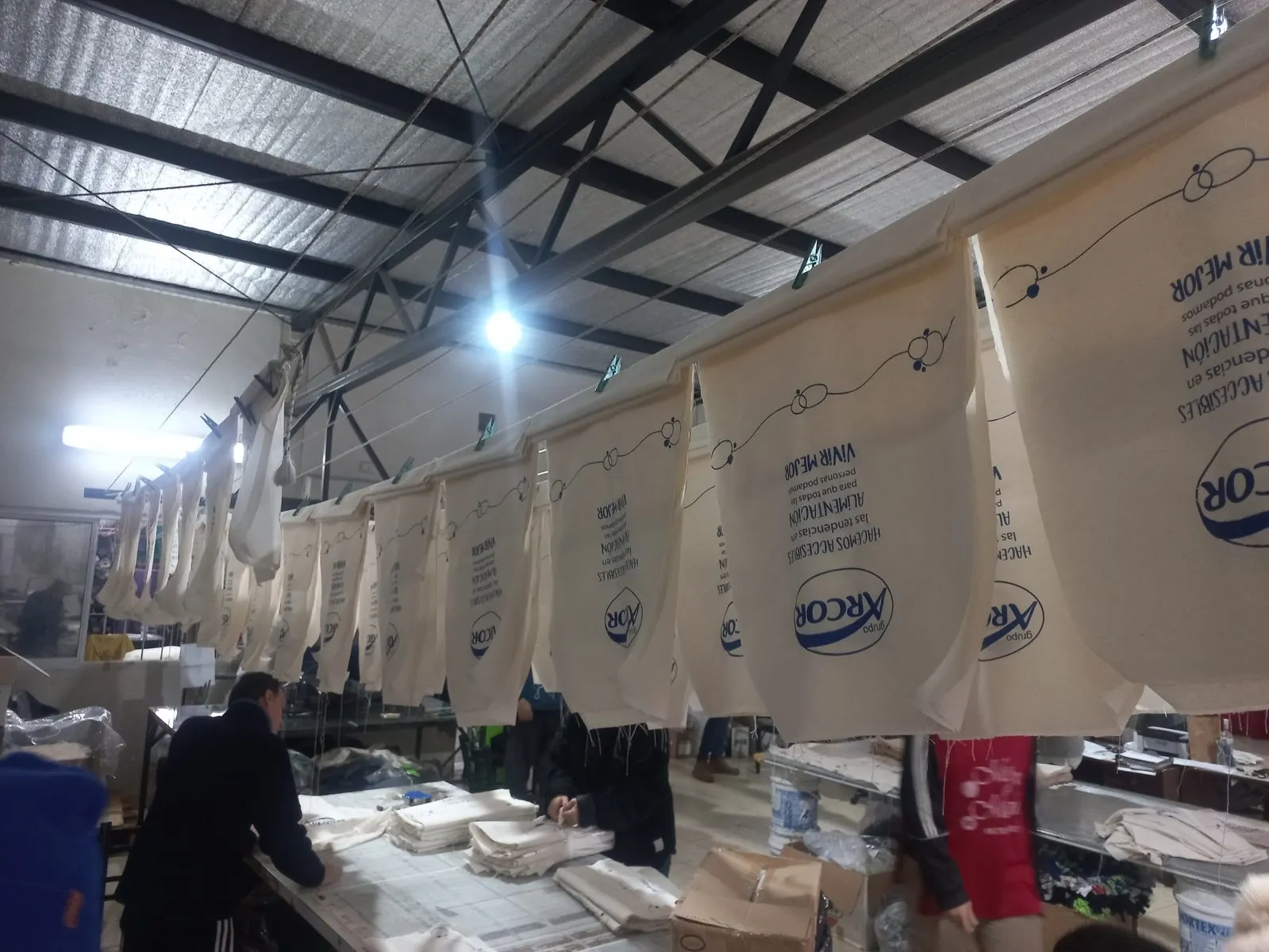 Nave del taller con decenas de bolsas serigrafiadas colgadas para secar