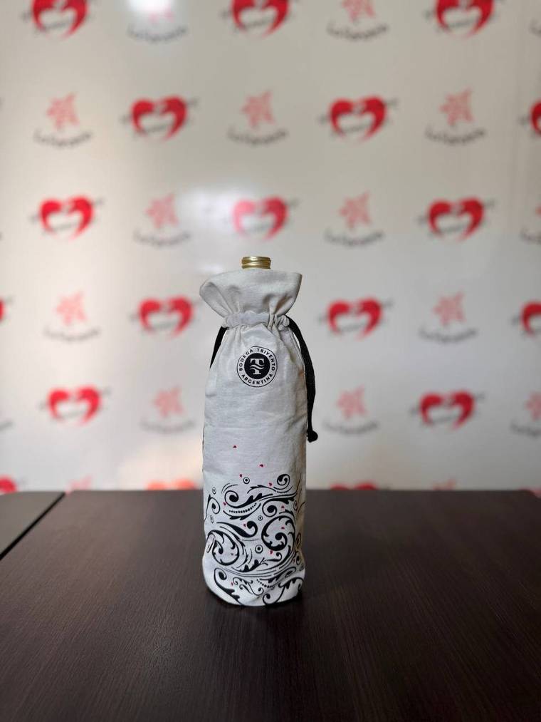 Funda de lienzo blanco con cordón negro cubriendo una botella de vino
